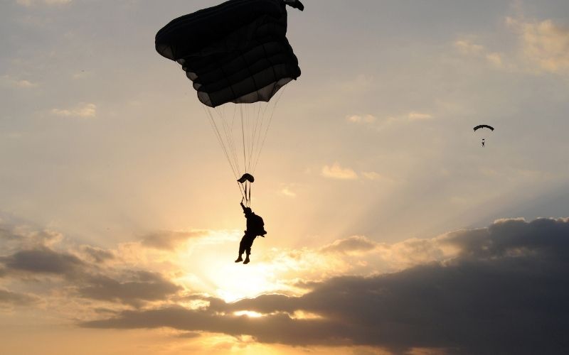 one jumping with parachute in air