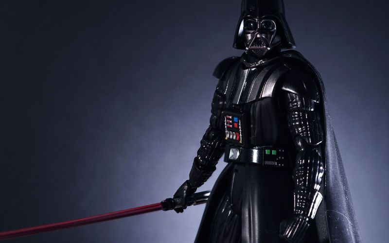 Darth Vader in a heavy armour is holding his lightsaber
