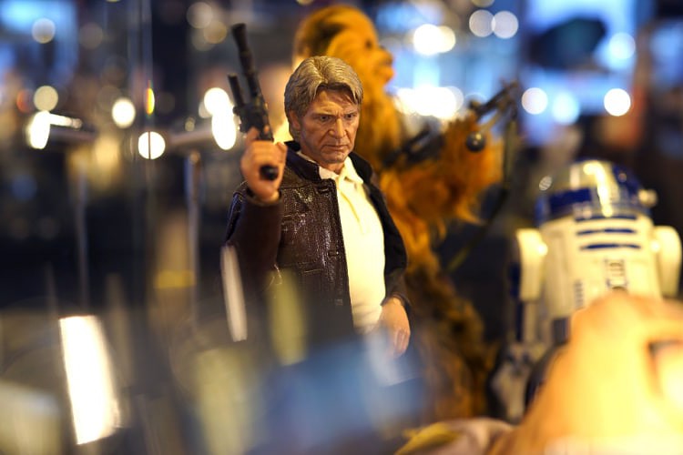 Old Han Solo holding his blaster and standing with Chewbacca and R2-D2