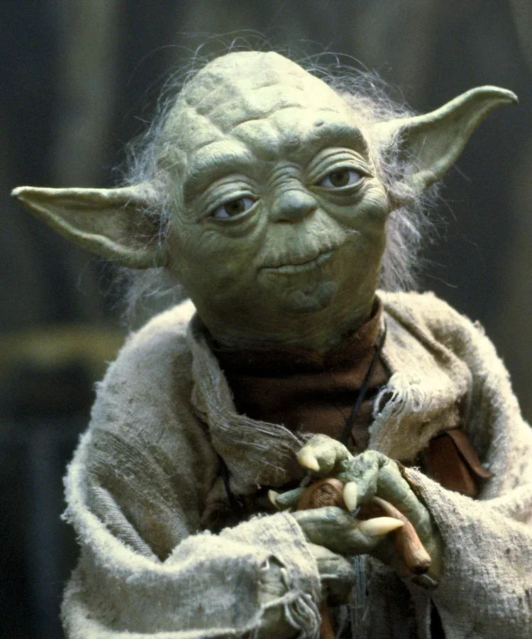 Yoda holding his green lightsaber