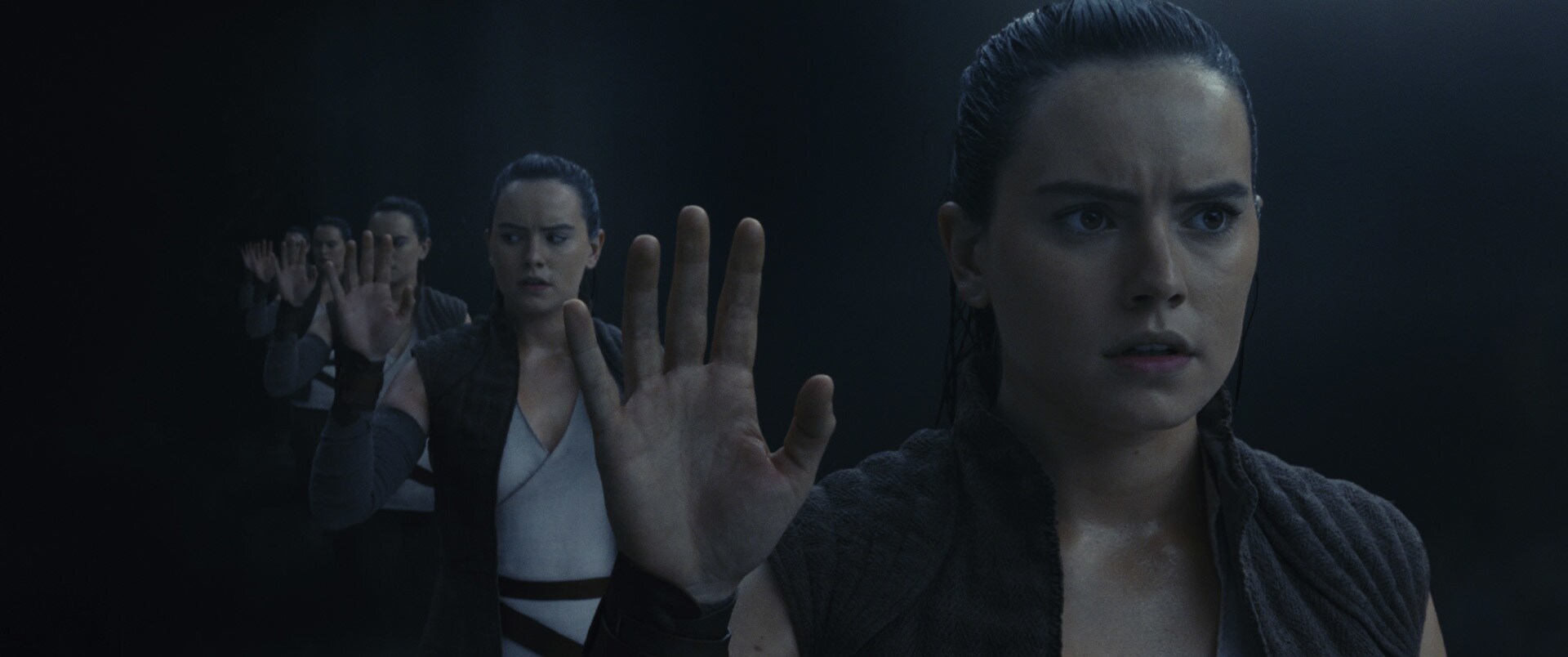 Rey looking into the reflective wall inside the cave on Ahch-To