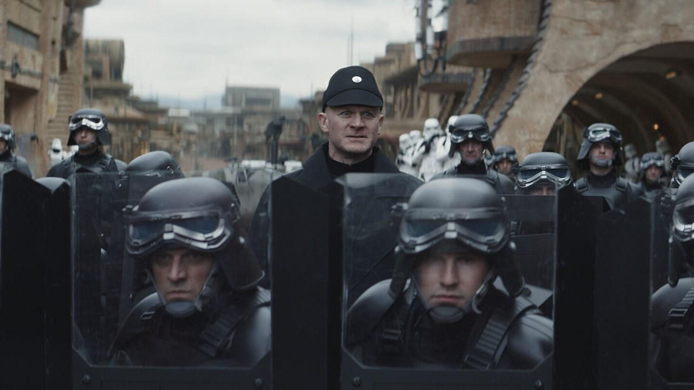 Imperial security troops carrying riot shields on Ferrix, with stormtroopers behind them